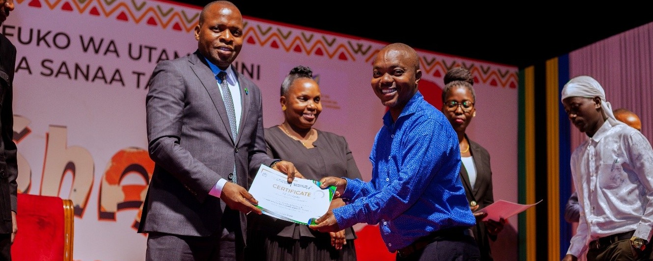 Katibu Mkuu wa Wizara ya Habari, Utamaduni, Sanaa na Michezo akikabidhi cheti kwa mshiriki wa warsha iliyofanyika katika ukumbi wa makumbusho ya taifa jijini Dar es salaam.